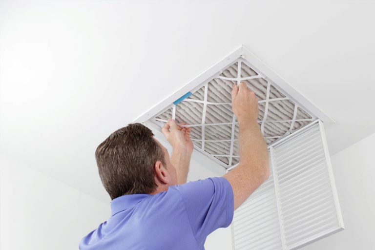 A man changing a furnace filter.
