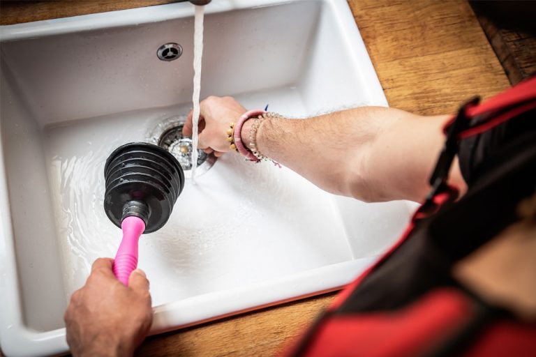 A plumber plunging a sink