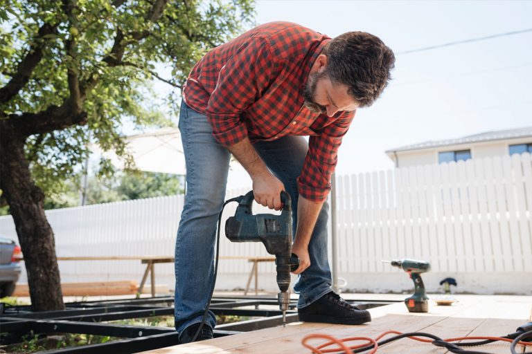 A person building a deck frame.