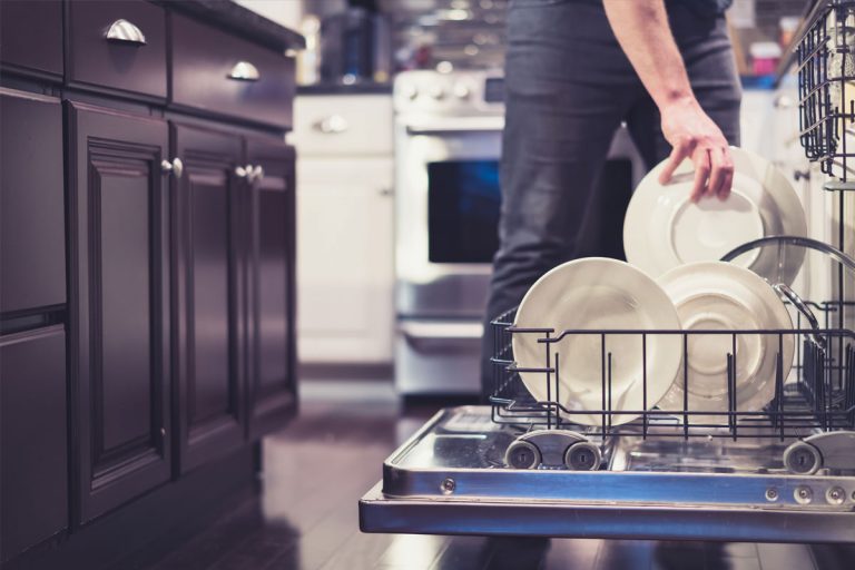 Someone putting dishes into a dishwasher.