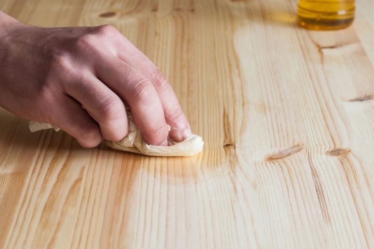 A person putting wax on wood.