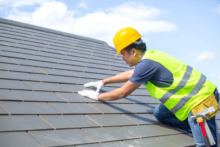 A man installing a metal roof on a house.