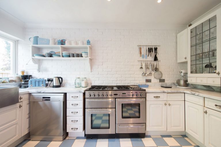 A stainless steel dishwasher and oven in a white kitchen.