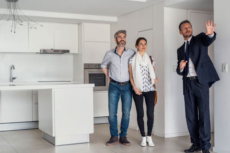 A realtor showing a couple a home.