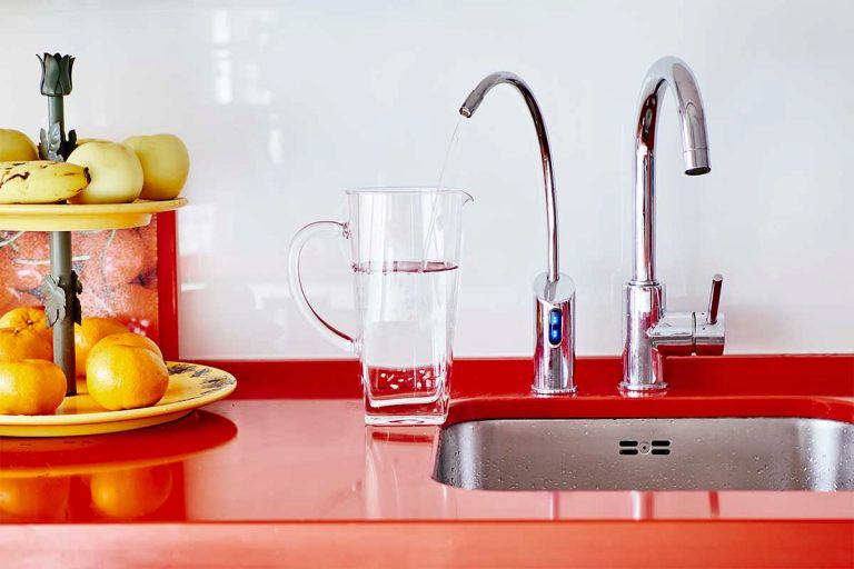 A tap filtration system in a kitchen with red counters.