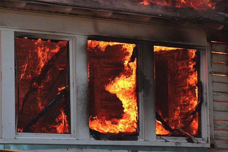 A fire-damaged window of a house.